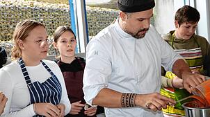 Niklas Osner von der Naturpark-Kochschule mit Schülern. Bild: Martha Weishaar