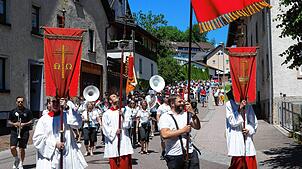 Marco Johner und die Ministranten schreiten als Fahnenträger der Prozession voran. Foto: Wolfgang Scheu