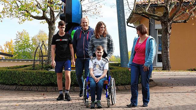 Familie Goppelsröder mit den Geschistern Julian (vorne im Rollstuhl), Marian  (links), Lea (hinten dritte von links) sowie den Eltern ...