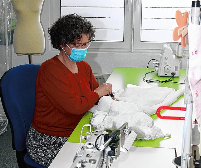 In der hauseigenen Schneiderei legt Schneiderin Christine Roth letzte Hand an einem Hochzeitskleid an.