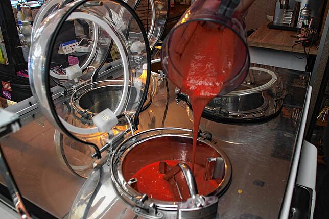 Calogero Giudice gießt die Himbeermasse in die Eismaschine. Das Eis darf dann 15 Minuten in der Maschine drehen, bis es eine cremige ...