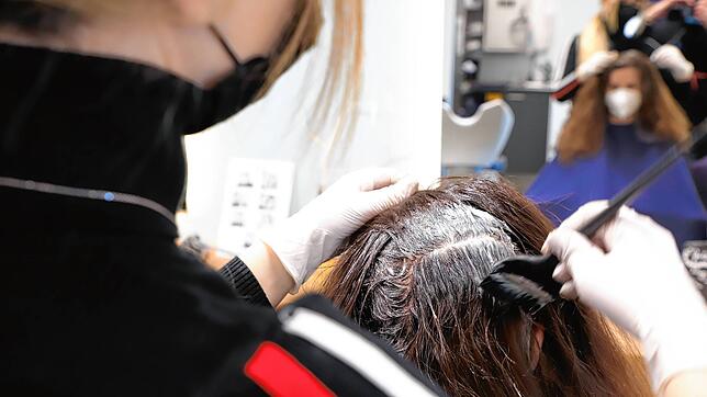 Eine Frisörin beim Haare färben. (Symbolbild)