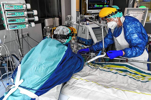 Pfleger in Schutzausrüstung versorgen einen Covid-19-Patienten auf der Intensivstation des Sint-Trudo Krankenhauses im belgischen St. ...