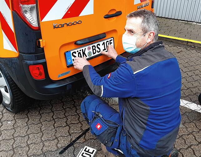 Martin Bootz, Mitarbeiter der Stadt Bad Säckingen, montiert eines der neuen SÄK-Kennzeichen ein ein Fahrzeug aus dem städtischen Fuhrpark.