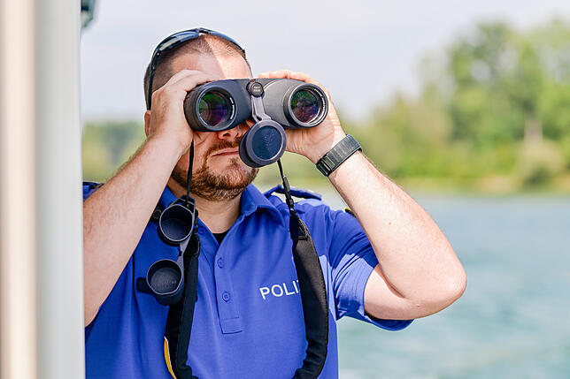 Mathias Helbling beobachtet den Rhein mit dem Fernglas.