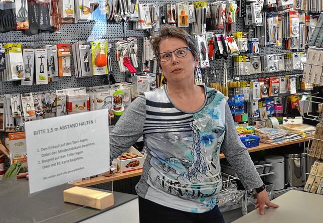 Sylvia Ströer von Haushaltswaren Guldin schützt sich durch Plexiglas.