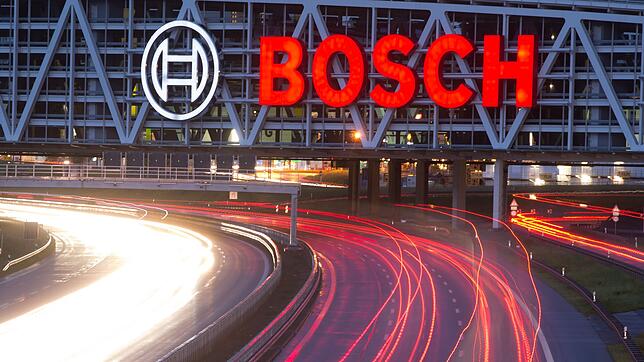 Autos fahren auf der Autobahn A8 unter einer Brücke mit dem Bosch-Logo entlang.