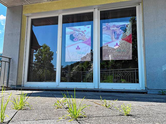 Professionelle Werbeplakate hängen in den Schaufenstern des chinesischen Massagesalons in Laufenburg.