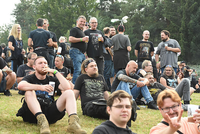 In Gruppen, stehend oder sitzend, präsentieren sich die Besucher auf dem Metalacker-Gelände.