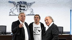 Der “Querdenken„-Initiator Michael Ballweg (m) steht mit den Rechtsanwälten Reinhard Löffler (l) und Rechtsanwalt Hans Böhme in einem ...