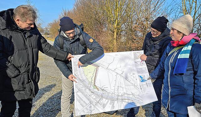 Die Experten Niels Ullrich (2.v.l.) und Gerhard Hauber (3.v.l.) zeigen am Plan, wo auf dem bisherigen Messeparkplatz P7 der Auwald ...