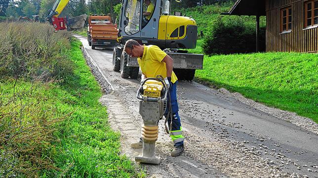 Bauhofmitarbeiter füllen das vom Starkregen weggespülte Bankett bei der Leitelsteighütte wieder auf und verdichten es. Bilder: Paul Haug