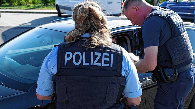 Bundespolizisten kontrollieren ein Fahrzeug. An Deutschlands Grenzen gibt es zusätzliche Kontrollen