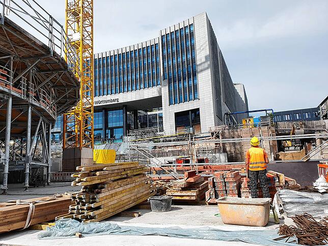 Baugrube im Herzen der Stadt – links wächst eine Kelchstütze, direkt daneben die Zentrale der Landesbank Baden-Württemberg.