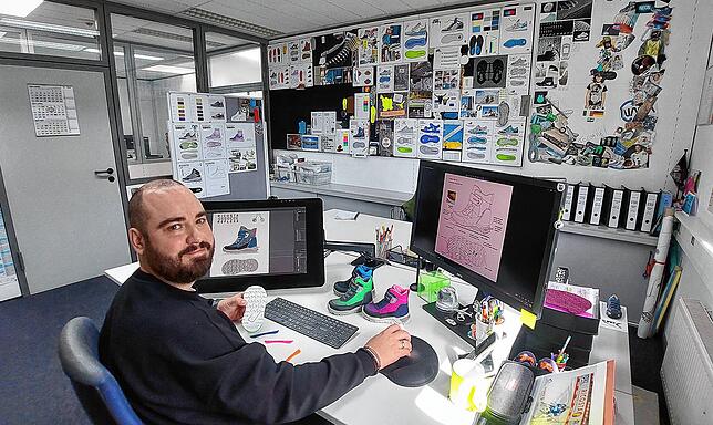 Ricosta-Designer Gerhard Gaiß an seinem Arbeitsplatz. Ihm gegenüber an einer Pinnwand hängen Ideen, Erfolge und Kreatives bunt gemischt.