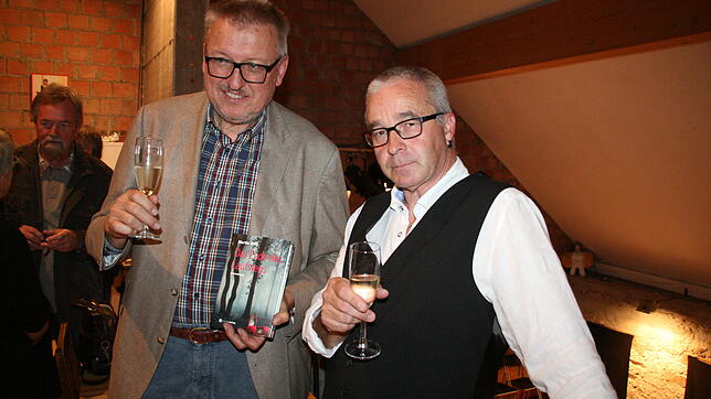 Verleger Manfred Hiefner (l.) und Martin Willi mit dessen Kriminalroman „Das Ende des Laufstegs“. Bild
