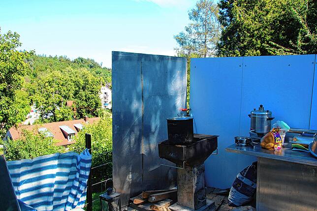 Der Grillplatz mit dem Rauchschutz, links das Haus, in dem die Schmidts wohnen.