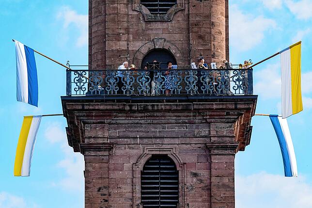 Vom Turm der Benediktinerkirche aus begleitet der evangelische Posaunenchor mit festlichen Klängen die katholische Fronleichnamsfeier.