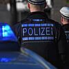 Polizisten stehen bei ihrem Einsatzwagen (Symbolbild). Nach einer Großfahdnung am Hochrhein wird in Waldshut ein 23-Jähriger festgenommen.