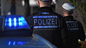 Polizisten stehen bei ihrem Einsatzwagen (Symbolbild). Nach einer Großfahdnung am Hochrhein wird in Waldshut ein 23-Jähriger festgenommen.