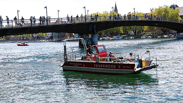 Boote der Polizei und Feuerwehr sowie die DLRG sind an der Suche auf dem Seerhein beteiligt.  Über dem Wasser kreist ein ...