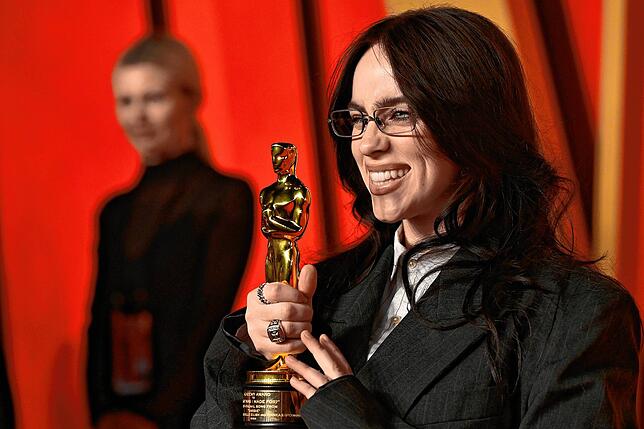 Billie Eilish kommt mit ihrem Preis zu den Fotografen.