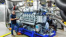 Ein Mitarbeiter von Rolls-Royce Power Systems neben einem MTU-Motor der Baureihe 4000. Noch mehr Motoren dieser Baureihe sollen in ...
