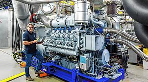 Ein Mitarbeiter von Rolls-Royce Power Systems neben einem MTU-Motor der Baureihe 4000. Noch mehr Motoren dieser Baureihe sollen in ...