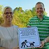 Andrea Renner und Thomas Pöppel zeigen das neue Hinweisschild, das Hundehalter in Reimform auf ihre Pflichten hinweist.