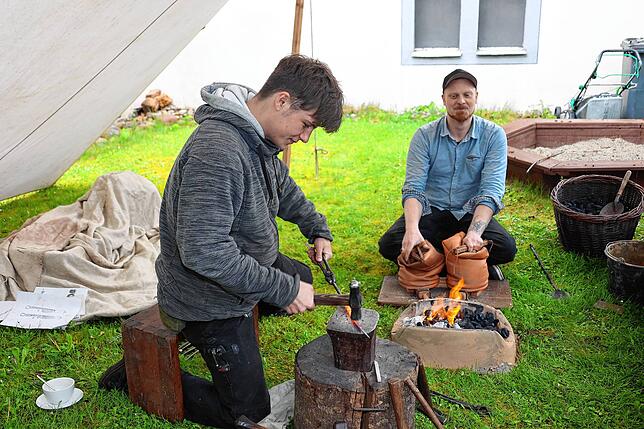 Während Pierre Stoll (rechts) das Schmiedefeuer weiter anfacht, schmiedet Jonathan Schubert eine Grillzange.