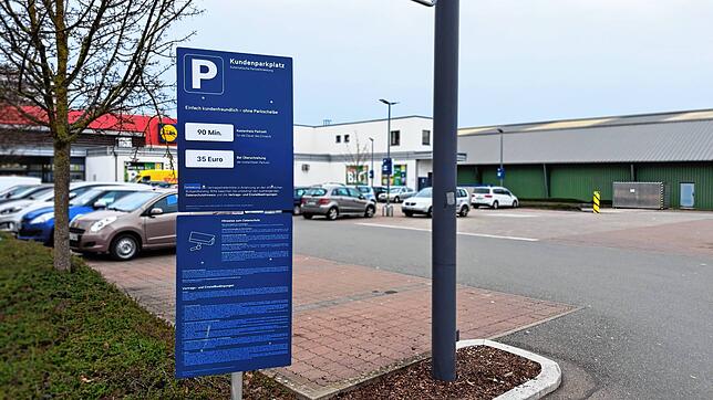 An der Einfahrt des Lidl-Parkplatzes steht gut sichtbar der Hinweis auf die erlaubte Parkzeit. An den Laternen auf dem Parkplatz sind ...