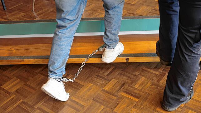 Der 21-jährige Angeklagte wird am ersten Prozesstag mit Fußfesseln in den Schwurgerichtssaal des Landgericht Konstanz geführt.