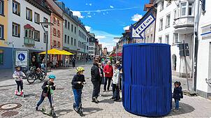 Was verbirgt sich hinter dem blauen Vorhang? Viele Besucher kommen zur SÜDKURIER-Aktion.