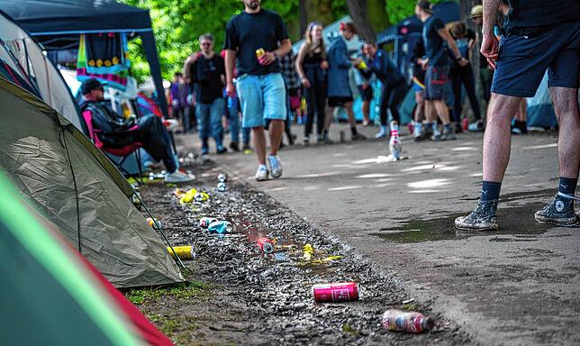 Mehrere leere Getränkedosen liegen im Matsch auf dem Camping-Gelände des Open-Air-Festivals „Rock im Park“ in Nürnberg.