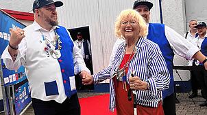 Jörg Uhrig, Tambour des Trommlerzugs, nimmt Trommlermotter Helga Duffner auf dem roten Teppich an die Hand. Mit dabei zweiter Tambour ...