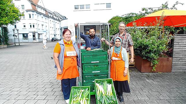 Tafel-Köchin Eva Pal (links) und die Mitarbeitenden Abdula Mohamed und Eva Dalal nehmen die Spende von Solawi-Akteur Wolfgang Pfrommer ...
