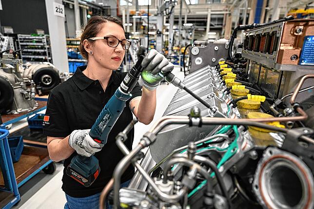 Eine Mitarbeiterin von Rolls Royce Power Systems baut einen Motor der MTU-Baureihe 2000 zusammen.