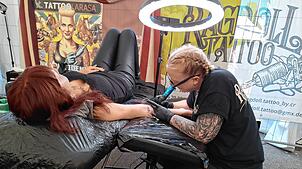 Corinna Rapp tätowiert eine Kundin bei der Tattoo-Convetion „Lakeside Wheels & Needles“ im Zelt im Seepark Linzgau.