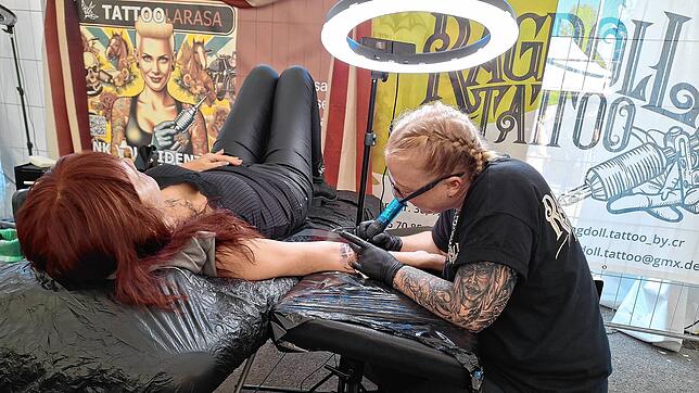 Corinna Rapp tätowiert eine Kundin bei der Tattoo-Convetion „Lakeside Wheels & Needles“ im Zelt im Seepark Linzgau.