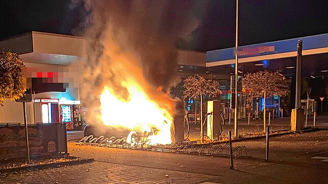 (Archivbild) Das Elektrofahrzeug an der Ladesäule brennt im November 2021 komplett aus. Direkt neben der Tankstelle.