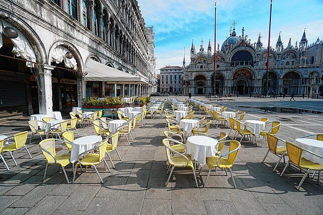 Leere Stühle vor einer Gaststätte in Venedig. In Italien wurden Restaurants geschlossen.