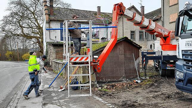 Die blauen Storchenabwehren müssen jetzt noch nach oben. Peter Krattenmacher ist bereits im Transportkorb und hält eine davon. Dabei ...
