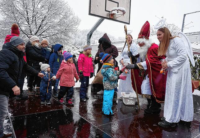 Der Nikolaus und sein Gefolge sind nicht mit leeren Händen zum Nikolausmarkt gekommen, die Kinder erhalten kleine Geschenke.