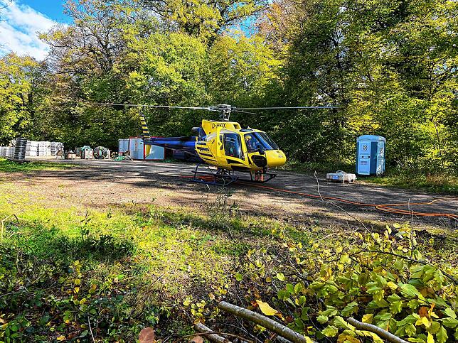 Der Helikopter auf dem Parkplatz bei der Marienschlucht. Dort bringt er am Seil Gehölz aus der Schlucht und Material hinein.