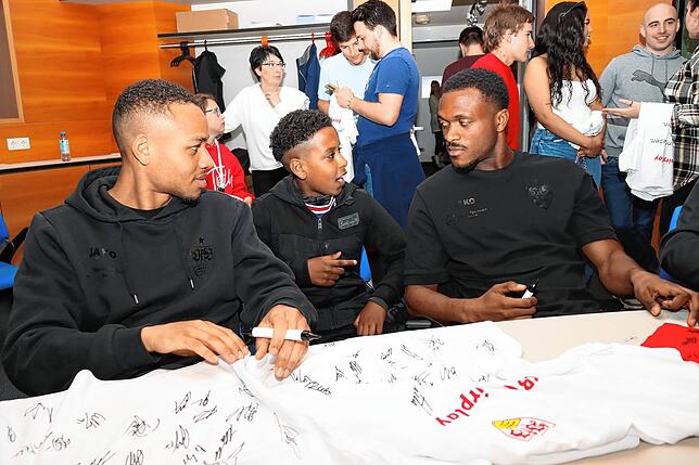 Dieser kleine Fan hat mit den Fußballern Nikolas Nartey (links) und Dan-Axel Zagadou (rechts) neue Freunde gewonnen.