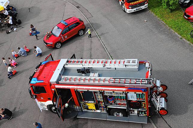Die geweihten Fahrzeuge vom Schlauchturm aus gesehen: vorn das Löschfahrzeug, dahinter der Kommandowagen.