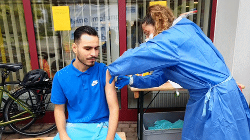 Delshad Belko bekommt in seiner Mittagspause von Krankenschwester Hala Hijazi vom mobilen Impfteam seinen ersten Piks.