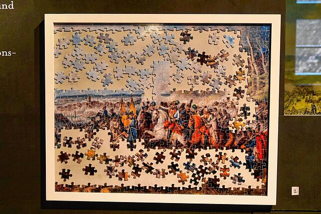 Die Schlacht bei Ostrach im Jahr 1799, nach einem Gemälde von Johann Baptist Pflug, ist als unvollendetes Puzzle von Nikolaus Mohr ...