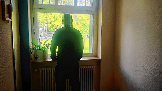 Ein Patient blickt aus dem Fenster im Erdgeschoss der Station 71.