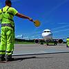 Ein Mitarbeiter des Bodensee-Airports weist ein Passagierflugzeug zu seinem Platz. (Archivbild)